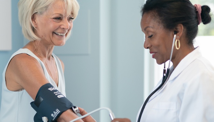 Doctor checks older woman's blood pressure