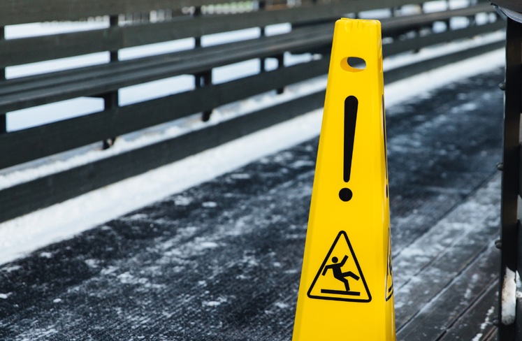 Safety sign warning of slipping hazard on frozen path