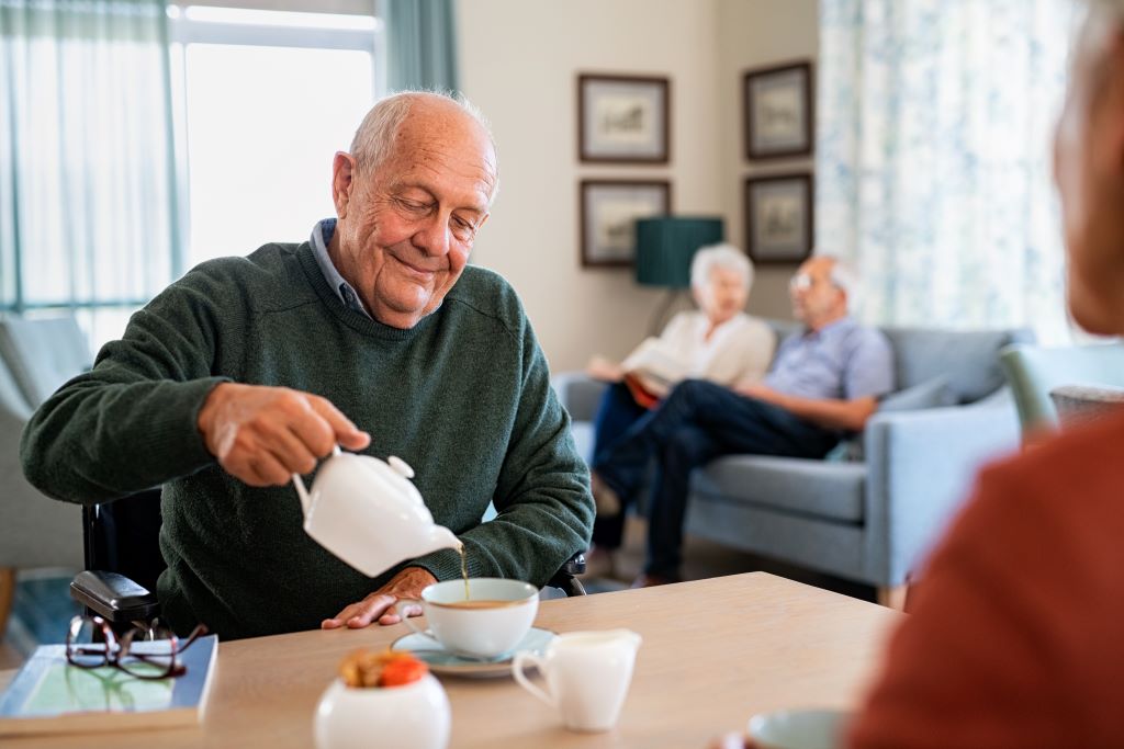 Older adult man drinking tea in an assisted living facility