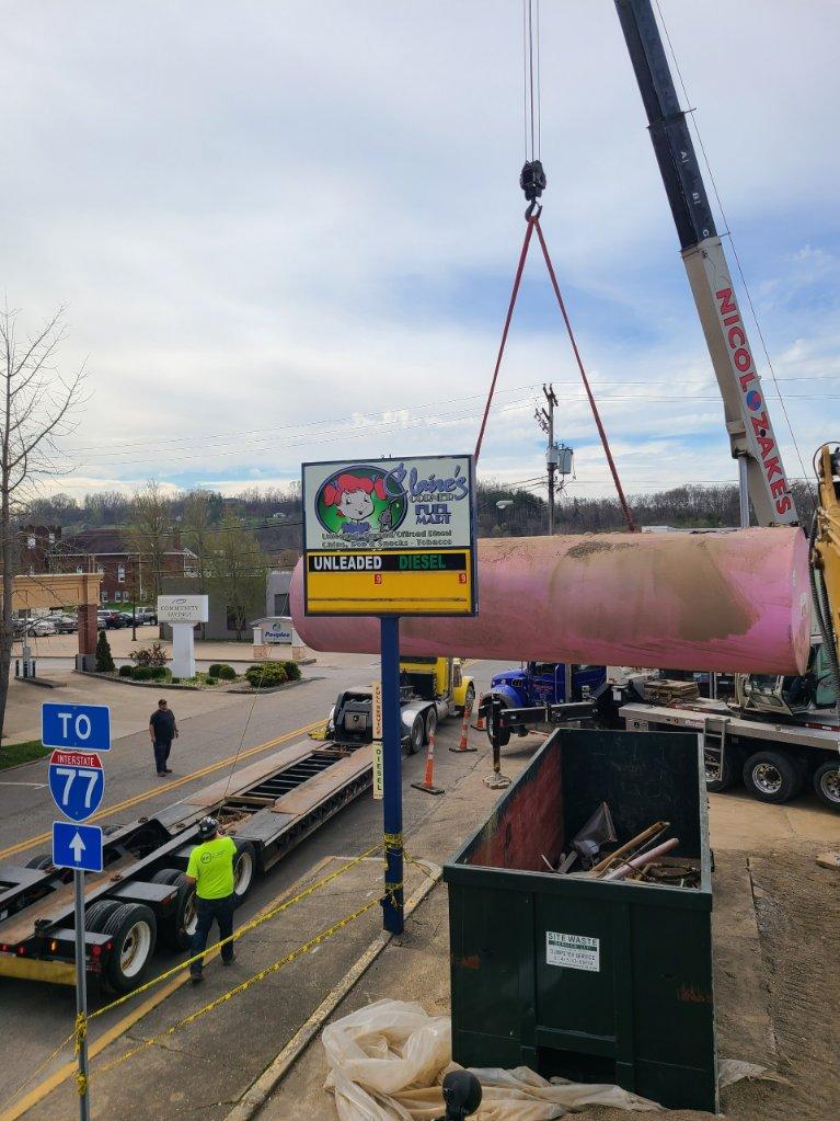 A crane lifts a fuel tank excavated from a former gas station in Noble County.