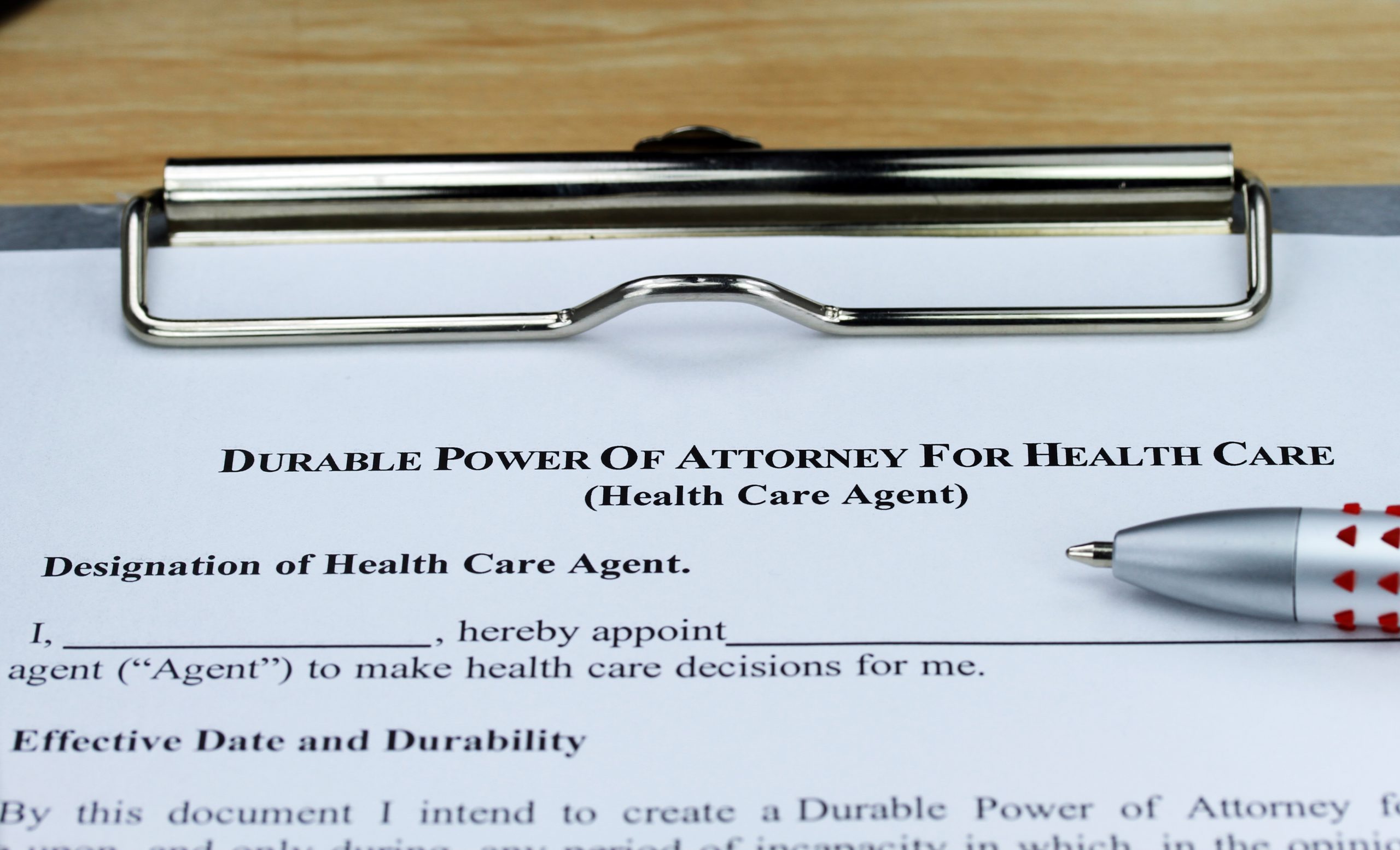 A Durable Power of Attorney form on a clipboard with a pen, ready to be filled out.