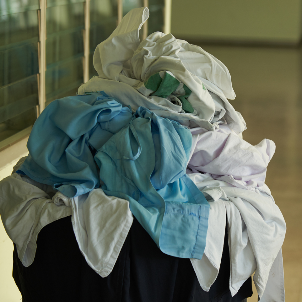 shot of a pile of laundry in a basket, appears to be sheets from a medical facility 