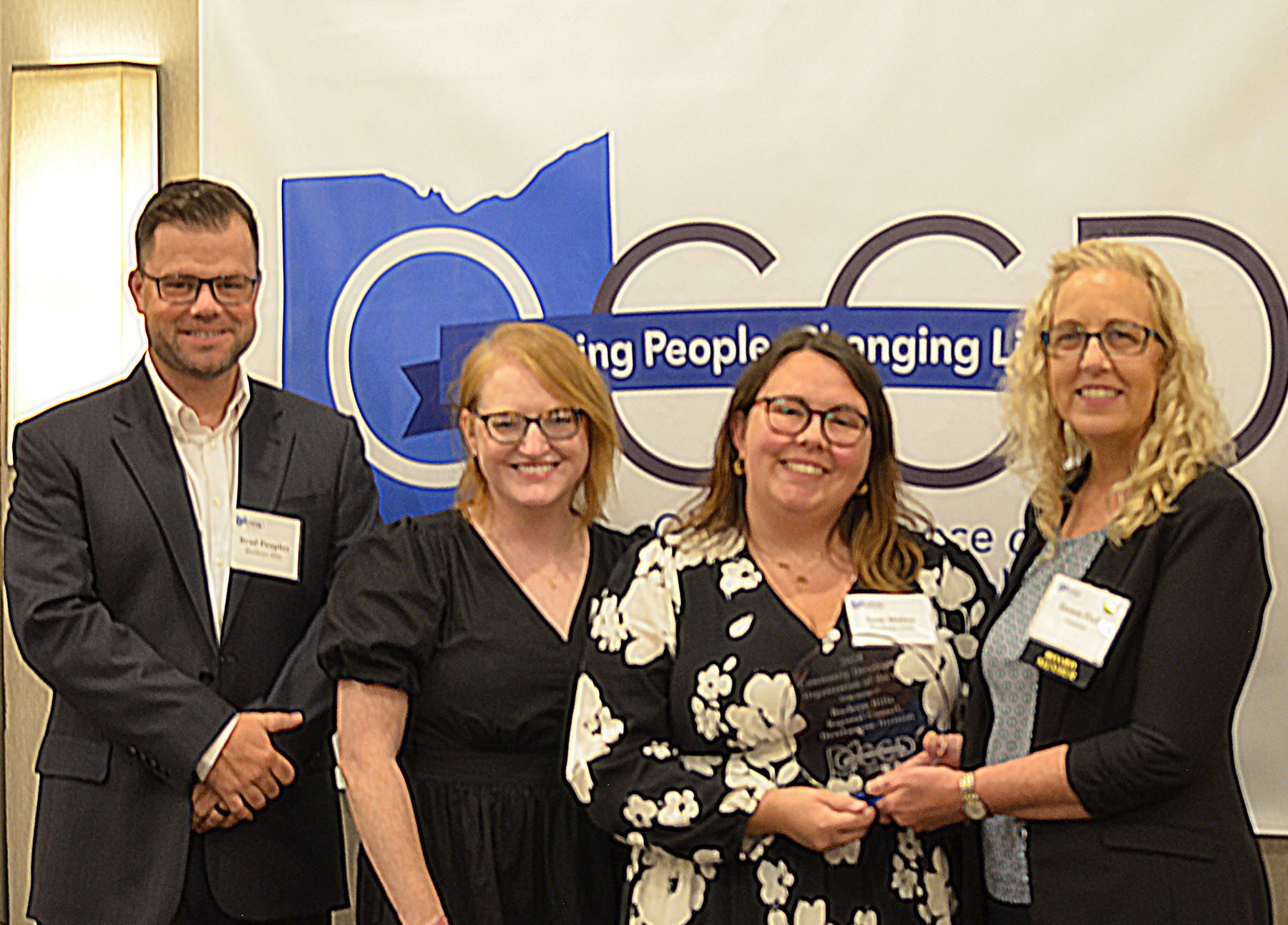 OCCD Board Member Dawn Fish presents the Community Development Department of the Year Award to BHRC Development Director Sam Miller, accompanied by Development Specialists Brad Peoples and Emma Yeager.