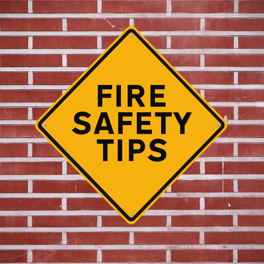 Large diamond shape sign against brick wall that reads "Fire Safety Tips"