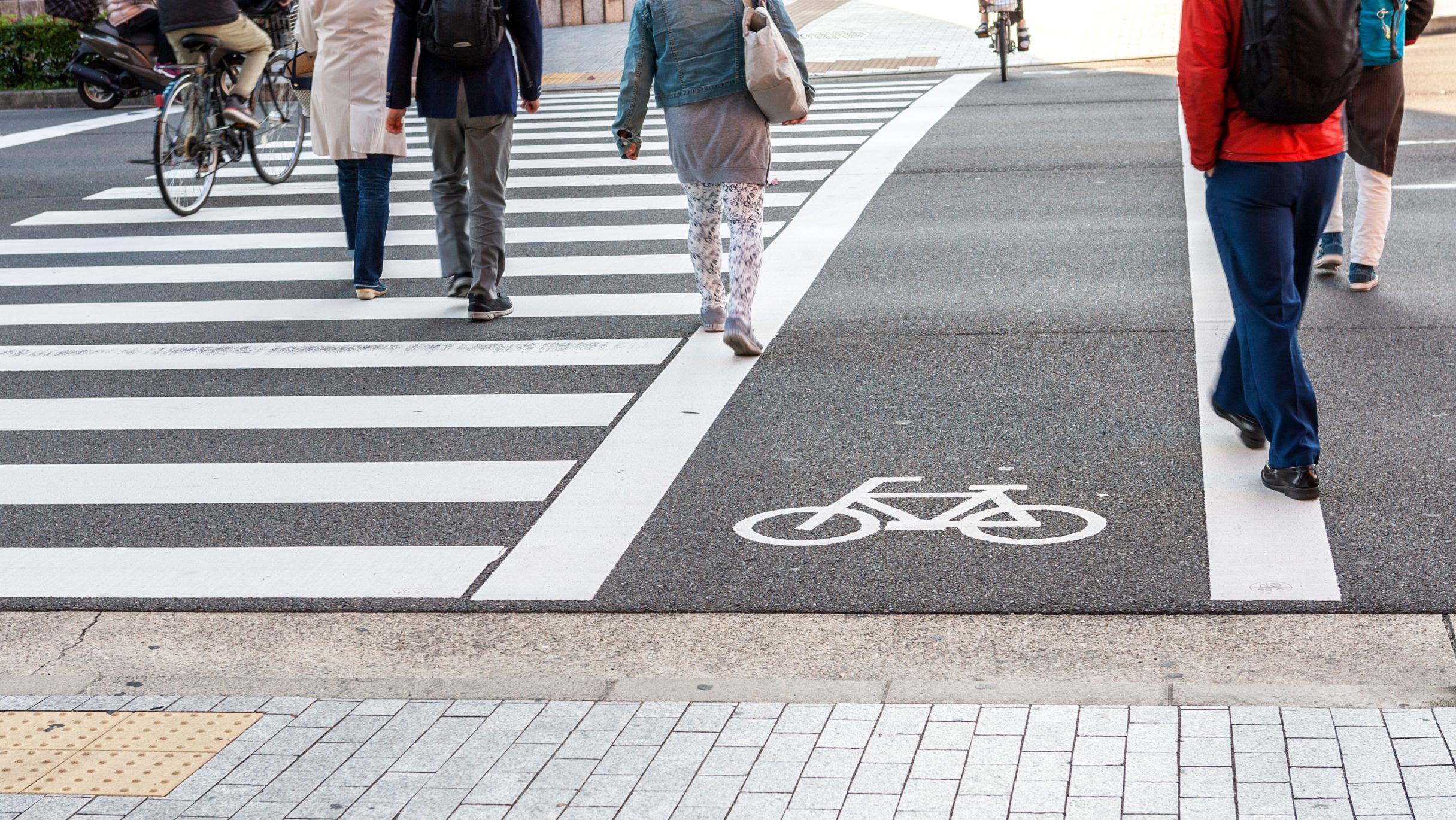 Crosswalk for people crossing on asphalt road with white bicycle symbol Traffic lane on asphalt road.