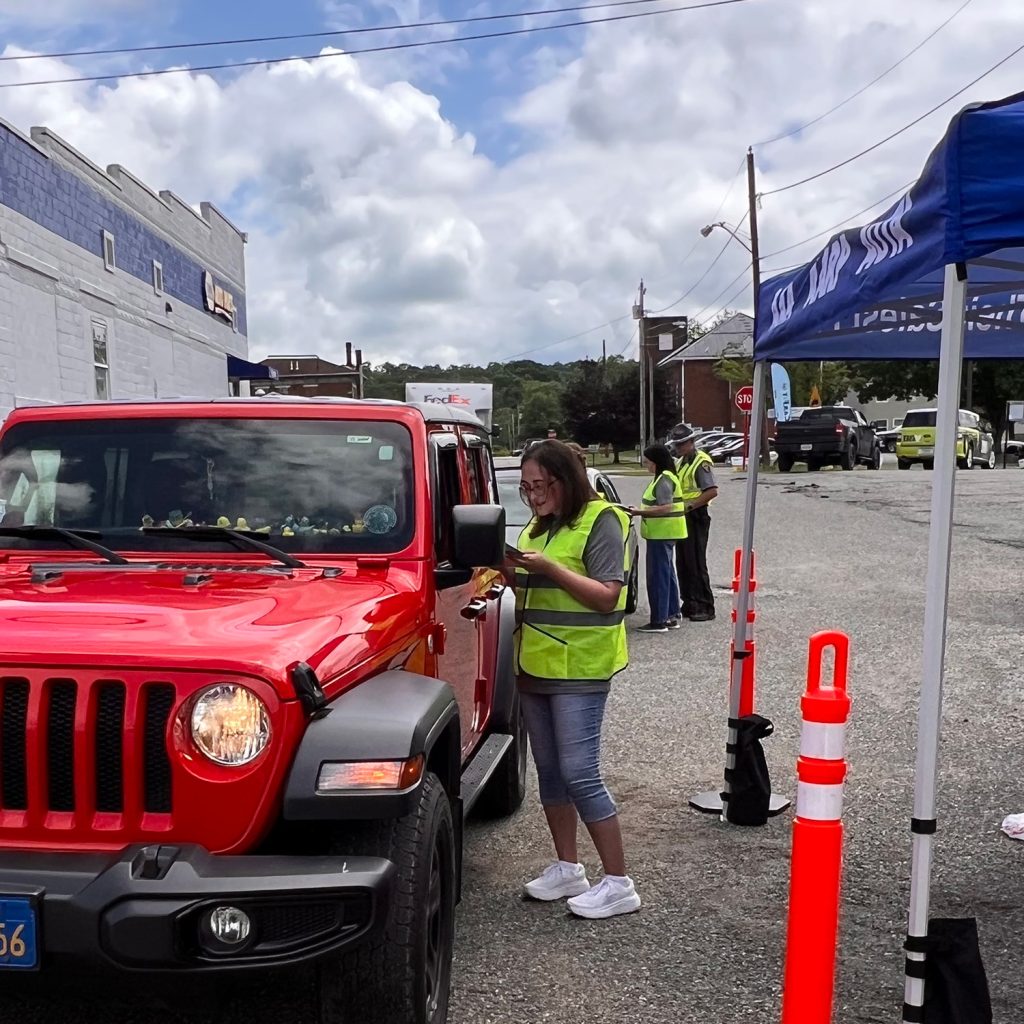 A CarFit volunteer speaks to a driver.