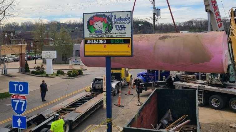 An underground fuel tank is removed from a former gas station.