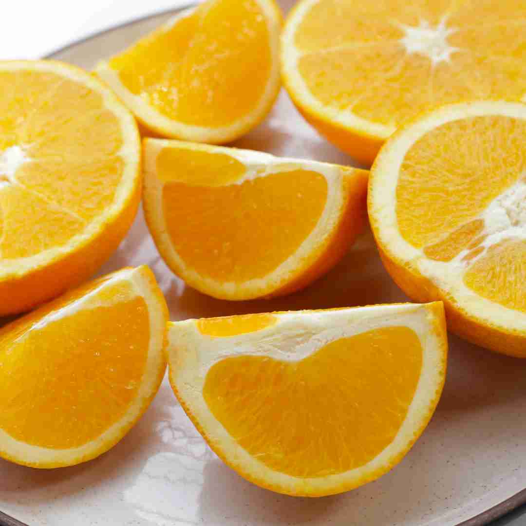 Several sliced oranges arranged on a plate.