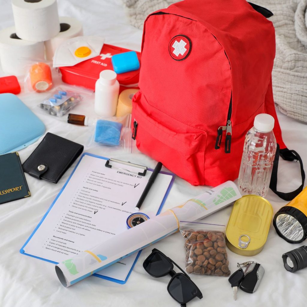 Emergency preparedness kit with backpack, water, flashlight, first aid supplies, and important documents.