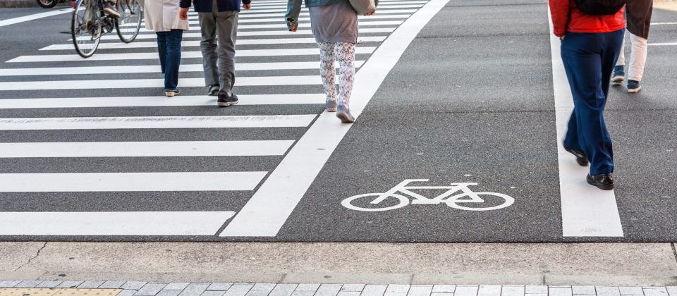 Crosswalk for people crossing on asphalt road with white bicycle symbol Traffic lane on asphalt road.