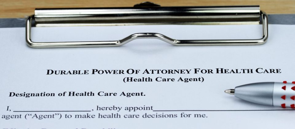 A Durable Power of Attorney form on a clipboard with a pen, ready to be filled out.