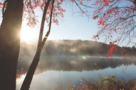 Fog over a lake with the sun rising over a ridge