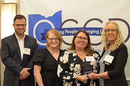 OCCD Board Member Dawn Fish presents the Community Development Department of the Year Award to BHRC Development Director Sam Miller, accompanied by Development Specialists Brad Peoples and Emma Yeager.