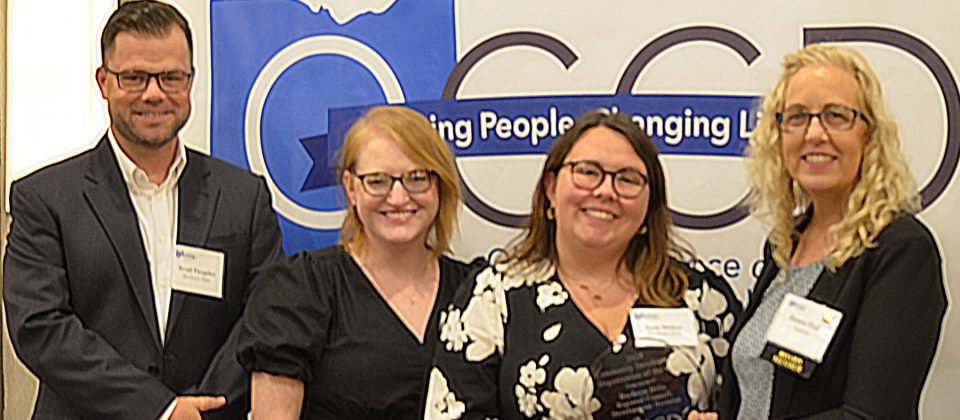 OCCD Board Member Dawn Fish presents the Community Development Department of the Year Award to BHRC Development Director Sam Miller, accompanied by Development Specialists Brad Peoples and Emma Yeager.