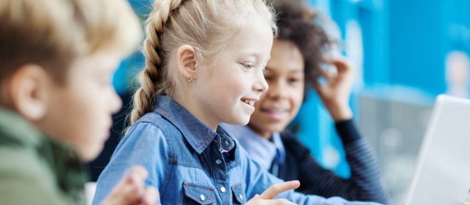 Young children accessing broadband internet using laptop