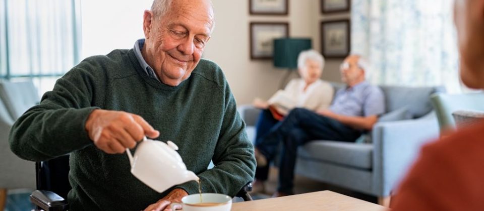 Older adult man drinking tea in an assisted living facility