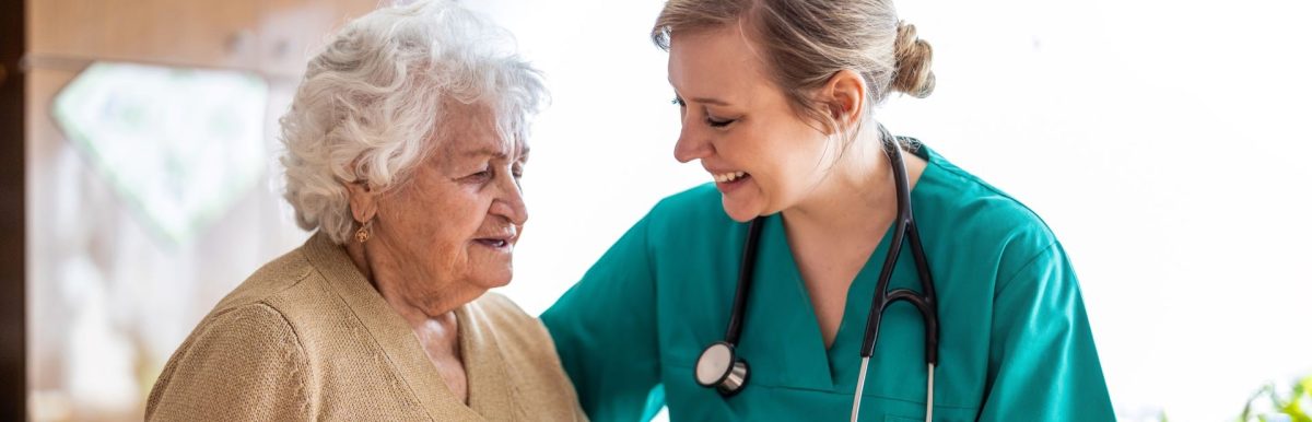 Nurse helping older adult woman in her home