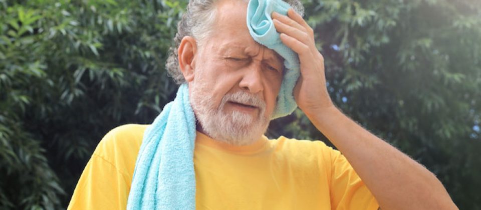 Older man wiping sweat during summer